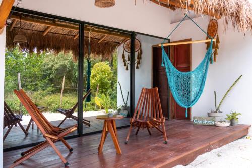 a porch with rocking chairs and a hammock at Ca Nikte Cabañas in El Cuyo