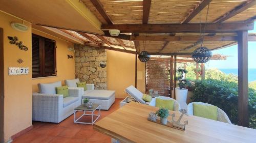a patio with couches and a table and a view of the ocean at Bougainvilla in Costa Paradiso