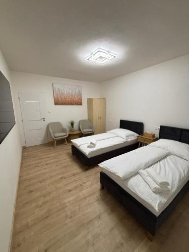 a bedroom with two beds and a table and chairs at ARD Apartment Nitra Centrum in Nitra