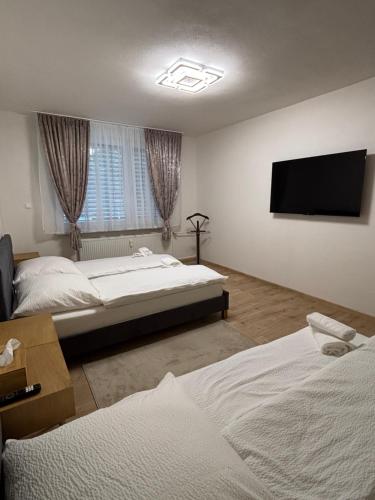 a bedroom with two beds and a flat screen tv at ARD Apartment Nitra Centrum in Nitra