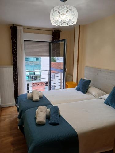 une chambre avec deux lits avec des serviettes dessus dans l'établissement Alojamiento Morriña, à O Pedrouzo