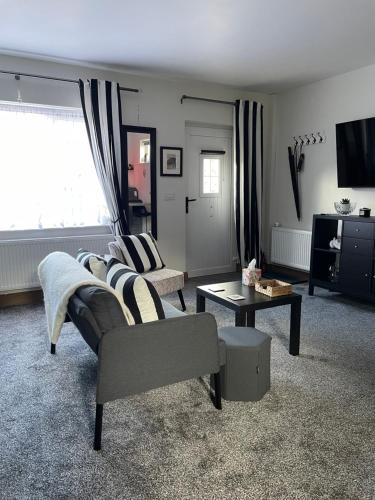a living room with a couch and a table at The Beehive at Pudding Cottage in Seapatrick