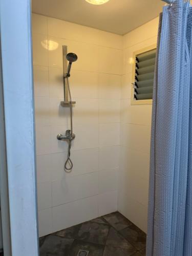 a shower in a bathroom with a shower curtain at הבית של דובי in Kefar Blum