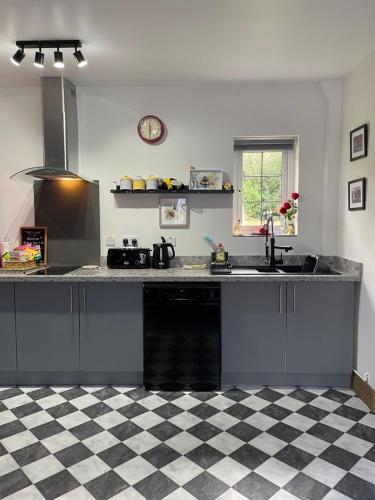 a kitchen with a black and white checkered floor at The Beehive at Pudding Cottage in Seapatrick
