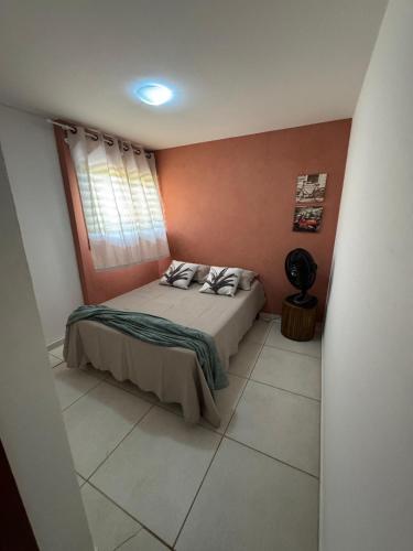 a small bedroom with a bed and a window at Chalés serra linda in Bananeiras