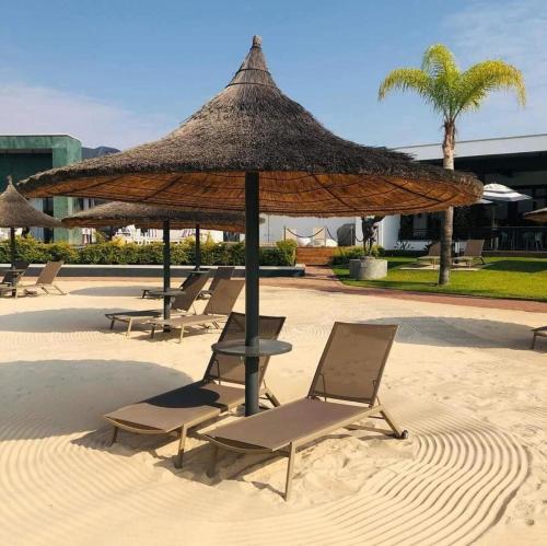 a group of chairs and an umbrella on a beach at 1 Bed Crystal Lagoon Escape in Pretoria