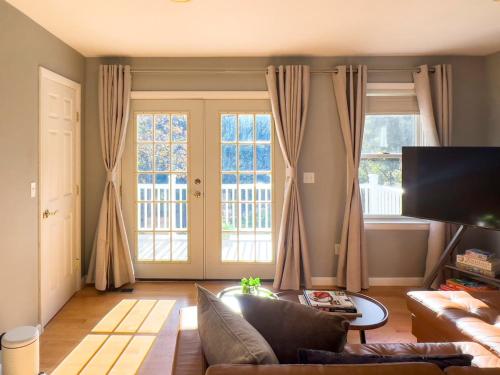 a living room with a couch and two windows at Serenity Haven - A Modern Retreat in Monroe