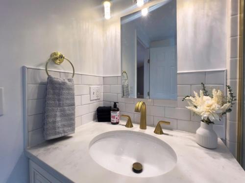 a white bathroom with a sink and a mirror at Serenity Haven - A Modern Retreat in Monroe