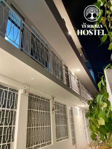 a building with a balcony in front of a hospital at La Terraza Hostel in Puerto Maldonado