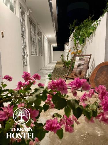 a group of pink flowers in front of a building at La Terraza Hostel in Puerto Maldonado