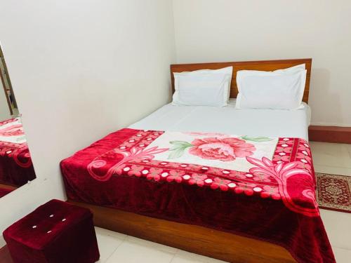 a bedroom with a bed with a red blanket on it at Hotel Rose Garden Palace Residential in Dhaka