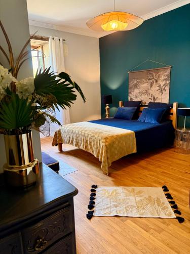 a bedroom with a bed and a vase of flowers at Le Patio Bleu in Saint-Romain