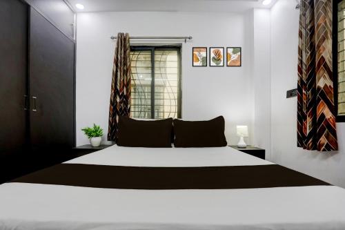 a bedroom with a large bed and a window at Hotel O Swarun and Banquet Hall in Gulzārbāgh