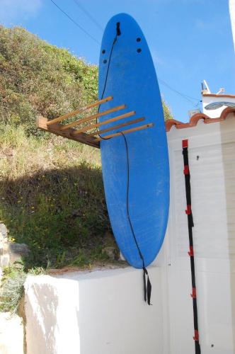 a blue surfboard on the side of a wall at Arrifana - CASA DAS MARÉS - Casa na Praia in Aljezur