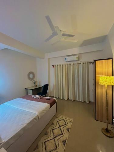 a bedroom with a bed and a ceiling fan at The Aura premium Homestay near Paltan bazar Gs road in Guwahati