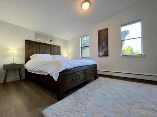 a bedroom with a large bed and a table and two windows at Eagles Nest Cozy Retreat Mtn Views in Vail