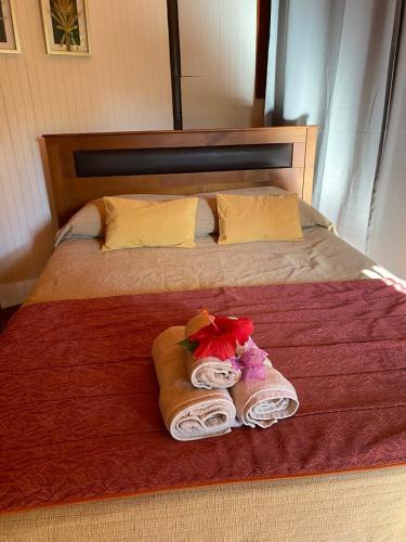 a bed with a towel and towels on it at Cabañas Hua'ai Village in Hanga Roa