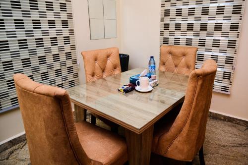 a dining room table with two chairs and a bottle of water at Ay crib 