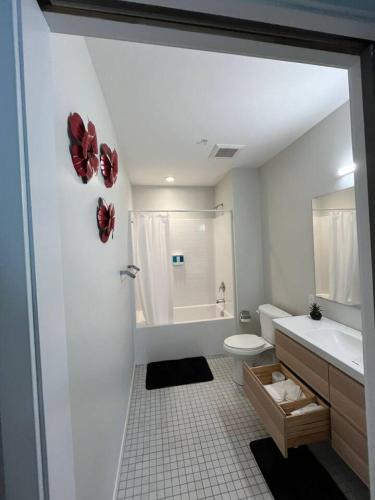 a white bathroom with a toilet and a sink at Red Velvet Studio in Des Moines