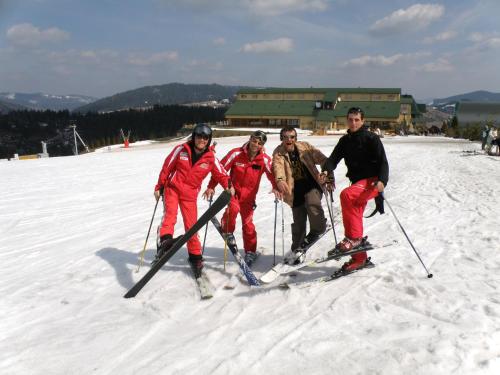 a group of four people on skis in the snow at Salamandra Village in Kozevo