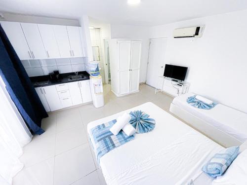 a large white room with a kitchen and a bed at CARIBBEAN SEA Hotel BEACH Vacation rental studios LONG TERM POOL SPA in Punta Cana