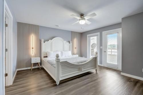 a bedroom with a white bed and a ceiling fan at Dells Lakefront Luxe Haven in Wisconsin Dells
