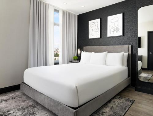 a bedroom with a large white bed and a window at Arthouse Hotel in New York