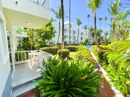 a porch of a house with palm trees and plants at CARIBBEAN SEA Hotel BEACH Vacation rental studios LONG TERM POOL SPA in Punta Cana
