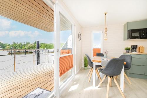 a kitchen with a balcony with a table and chairs at Hausboot MeerZeit an der Ostsee in Stralsund