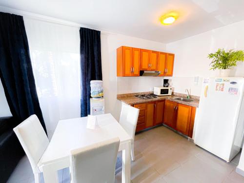 a kitchen with a white table and a white refrigerator at CARIBBEAN SEA Hotel BEACH Vacation rental studios LONG TERM POOL SPA in Punta Cana