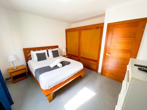 a bedroom with a large bed with a wooden headboard at CARIBBEAN SEA Hotel BEACH Vacation rental studios LONG TERM POOL SPA in Punta Cana