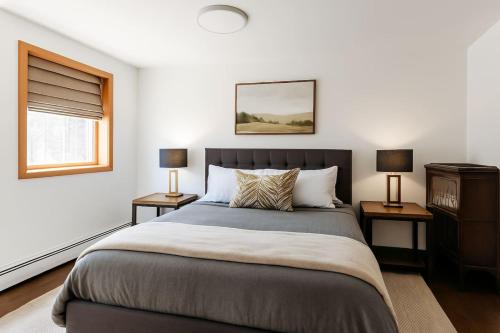 a bedroom with a large bed and two lamps at Drift Haus 4 and half BR Mountain Lodge in Windham