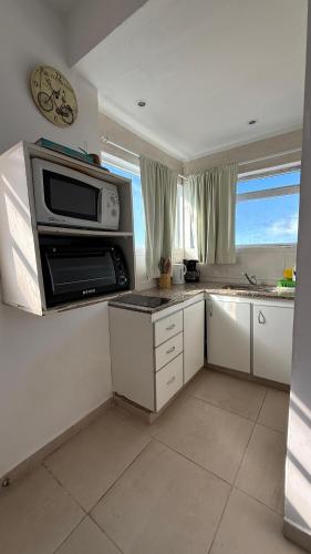 a kitchen with a microwave oven and a sink at TIDES Apart de playa in Ostende
