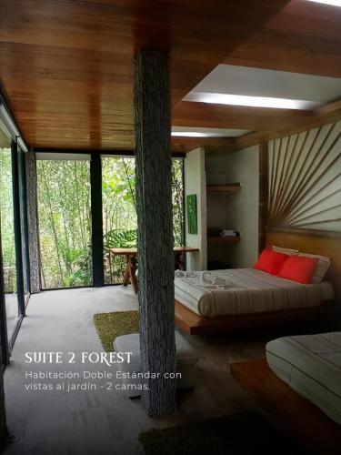 a bedroom with a tree in the middle of it at Subtropica Forest Suites in Mindo