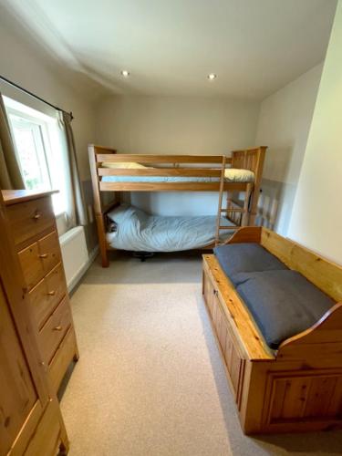 a bedroom with two bunk beds and a window at Smith Yard Cottage, Ashbourne in Ashbourne