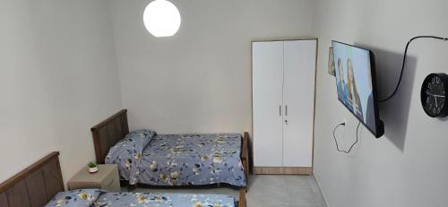 a bedroom with two twin beds and a clock on the wall at Adi's house in Tirana