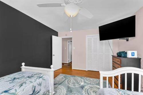 a bedroom with a bed and a flat screen tv at Spacious Augusta Retreat Near Augusta National in Augusta