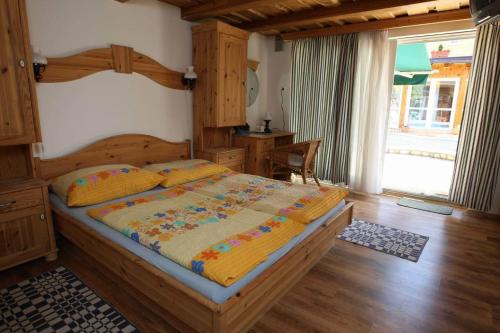 a bedroom with a large wooden bed in a room at Gasthaus Joó-Wellness Pension in Rábapaty
