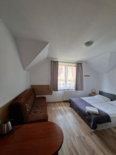 a bedroom with a bed and a couch at Giecowka in Polańczyk
