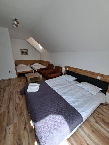 a bedroom with a large bed and a chair at Giecowka in Polańczyk
