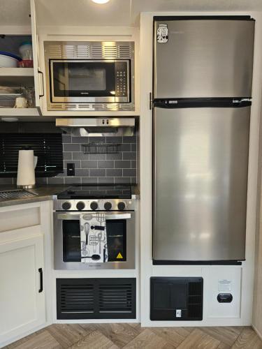a kitchen with a stainless steel refrigerator and microwave at Tranquil Stay Close to Hotspots 
