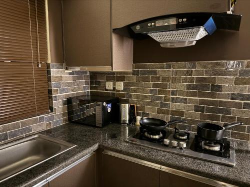 a kitchen counter with a stove and a microwave at SkyLuxe Studio 2 with rooftop Pool & Self Check In in Islamabad