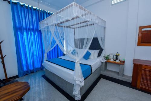 a bedroom with a bed with a canopy at Camellia Unawatuna in Unawatuna