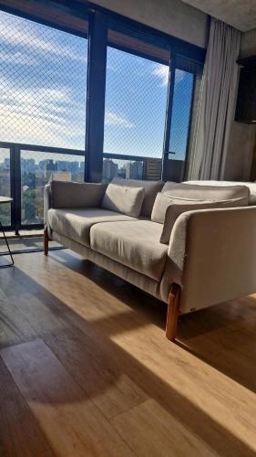 a large couch in a room with large windows at MyHome - Studio de Luxo perto do Iguatemi in Porto Alegre