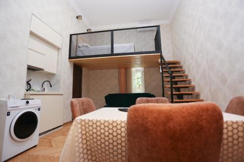 Una habitación con una mesa y sillas y una escalera. en Daisy Hotel Kutaisi, en Kutaisi