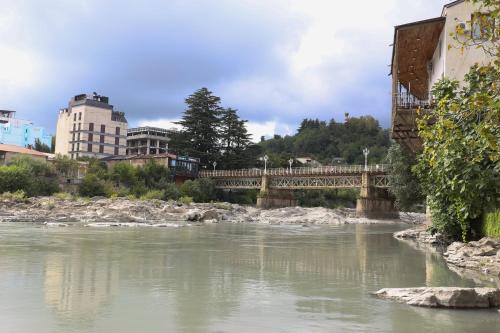 un puente sobre un río con edificios en el fondo en Daisy Hotel Kutaisi, en Kutaisi