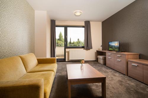 a living room with a couch and a table at Hotel Panorama in Štrbské Pleso