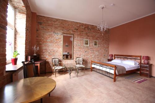 sypialnia z łóżkiem i ceglaną ścianą w obiekcie Nowy Rynek 10 w mieście Płock