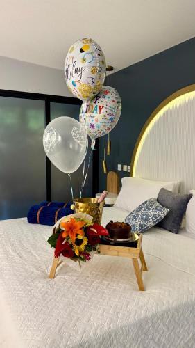 a tray with balloons and flowers on a bed at La Font Ecolodge in Buenavista