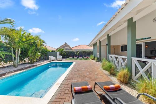 a swimming pool with lounge chairs next to a house at Casa Juno in Fontein